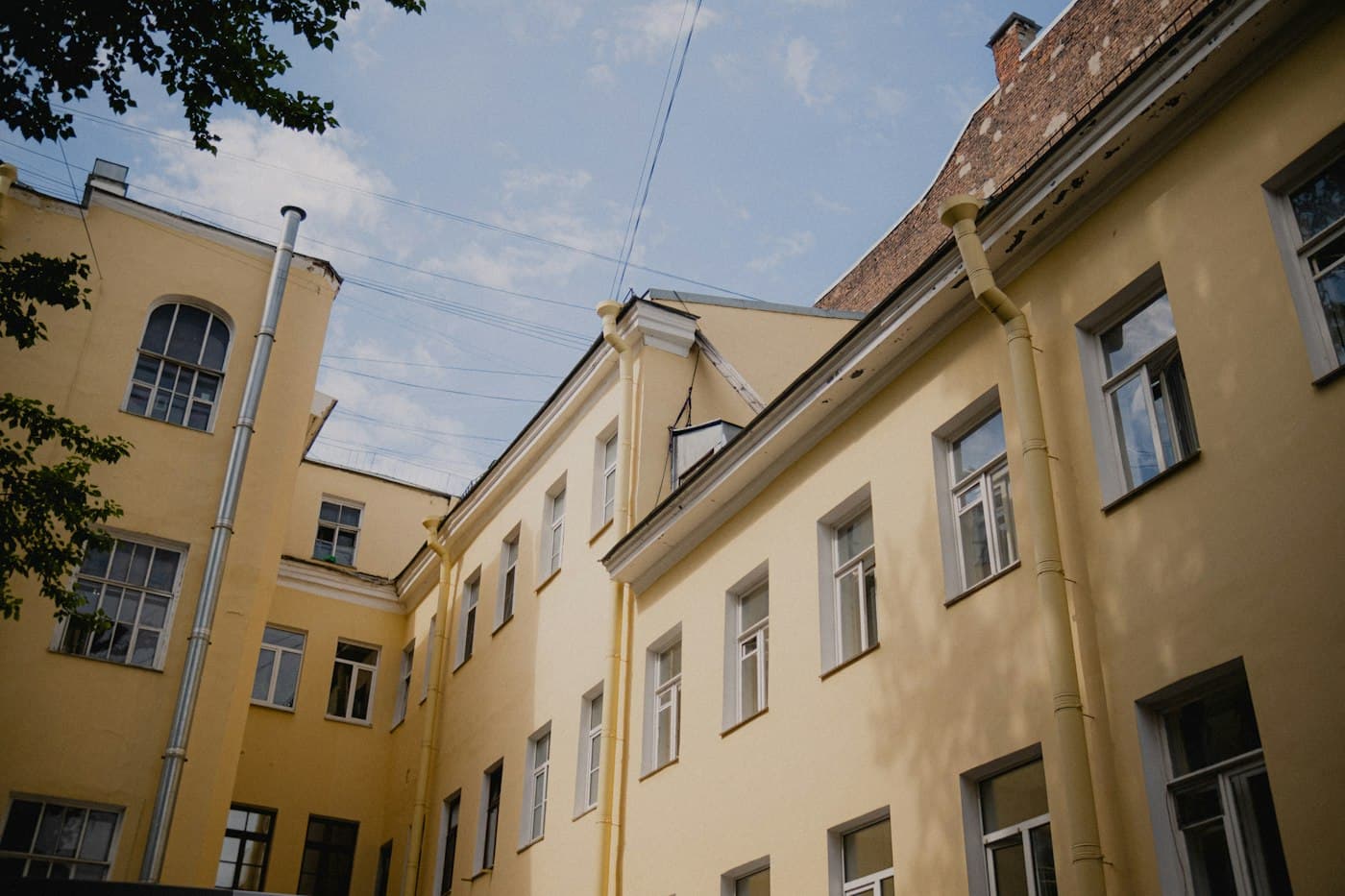 Blick nach oben zwischen Altbaufassaden